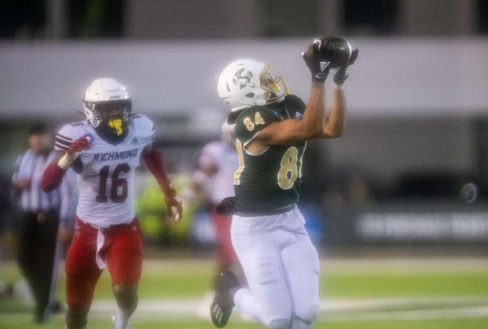 Sacramento State Hornets wide receiver Pierre Williams (84) pulls in a 51-yard pass for the winning score, as Richmond Spiders defensive back Aamir Hall (16) follows at left, during the fourth quarter of a wet NCAA FCS college football playoff game Saturday, Dec. 3, 2022, at Hornet Stadium in Sacramento.