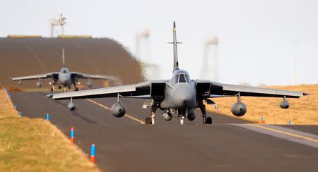 Royal Air Force Tornado jet aircraft taxi on the runway before taking off from RAF Lossiemouth airbase in Moray, northern Scotland March 1, 2011. REUTERS/David Moir
