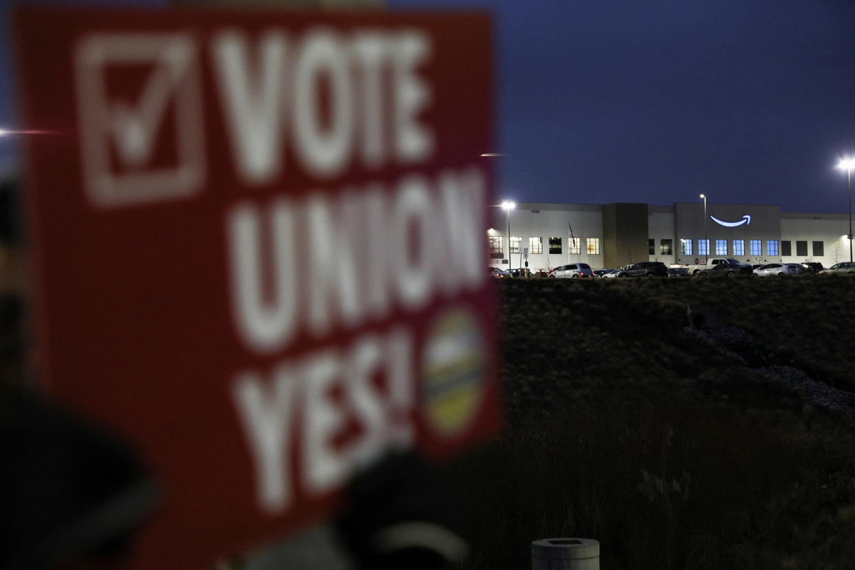 A person affiliated with RWDSU (Retail, Wholesale and Department Store Union) holds a sign supporting unionization in front of an Amazon facility on the first day of the unionization vote in Bessemer,  Alabama, U.S., February 4, 2022. REUTERS/Dustin Chambers