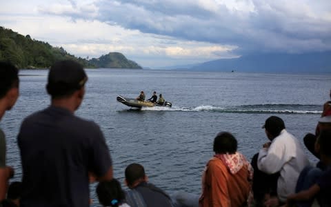 Rescue team member using a rubber boat  - Credit: REUTERS/Beawiharta