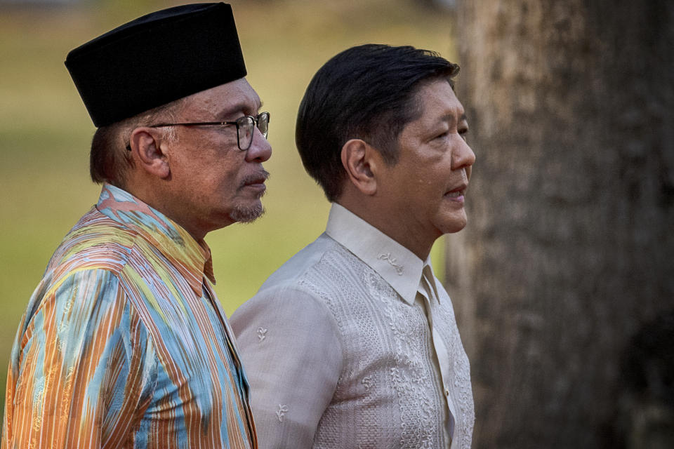 Malaysian Prime Minister Anwar Ibrahim, left, and Philippine President Ferdinand Marcos Jr. review an honor guard during a welcome ceremony at Malacanang Palace on Wednesday, March 1, 2023 in Manila, Philippines. (Ezra Acayan/Pool Photo via AP)