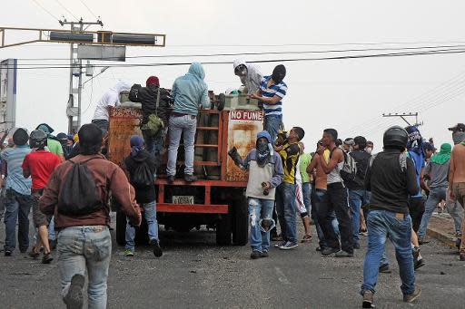 Manifestantes y residentes locales saquean un camión repleto de tanques de gas doméstico durante una protesta contra el gobierno de Venezuela, en San Cristóbal, Venezuela, el 28 de marzo de 2014. (AFP | George Castellano)