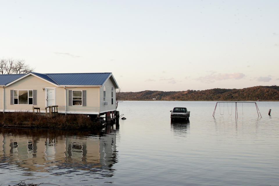 In this Tuesday, Oct. 22, 2019 photo, a home is surrounded by floodwaters in Bartlett, Iowa. Flooding along the Missouri River has stretched on for seven months in places and could endure through the winter, leaving some Upper Midwest farmland and possibly some homes encased in ice. (AP Photo/Nati Harnik)