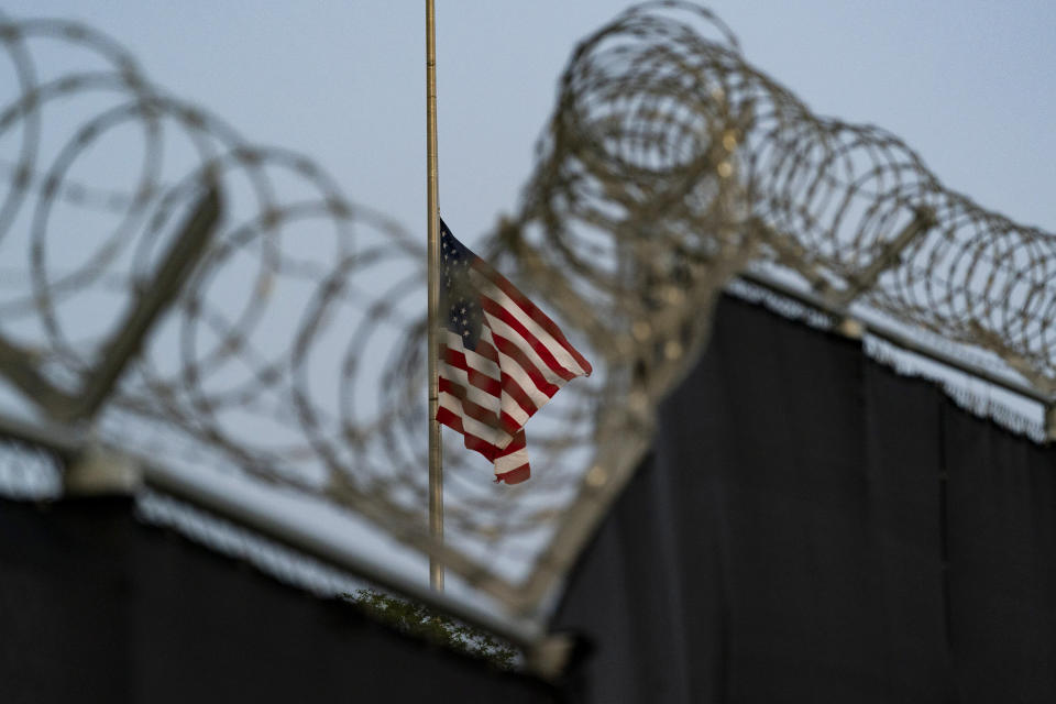 FILE - In this Aug. 29, 2021, file photo reviewed by U.S. military officials, a flag flies at half-staff in honor of the U.S. service members and other victims killed in the terrorist attack in Kabul, Afghanistan, as seen from Camp Justice in Guantanamo Bay Naval Base, Cuba. Camp Justice is where the military commission proceedings are held for detainees charged with war crimes. The White House says it intends to shutter the prison on the U.S. base in Cuba, which opened in January 2002 and where most of the 39 men still held have never been charged with a crime. (AP Photo/Alex Brandon, File)