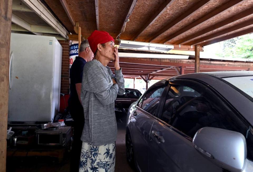 Saing Chhoeun stands in his garage looking at the home on Galway Drive in Charlotte where four law enforcement officers were fatally shot in April. Chhoeun was locked outside his house and livestreamed the shootout.