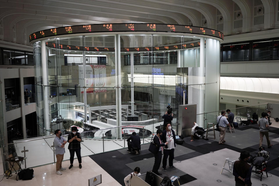 Journalists film an electronic stock board showing reopened Japan's Nikkei 225 index at Tokyo Stock Exchange in Tokyo Friday, Oct. 2, 2020. Tokyo's market resumed trading Friday after a full-day outage due to a malfunction in its computer systems. (AP Photo/Eugene Hoshiko)