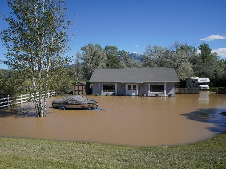 house and boat in floodwaters