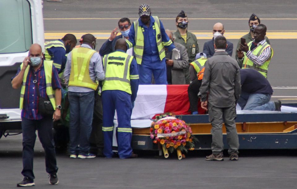 The coffins of Italian ambassador to Congo Luca Attanasio and Carabinieri officer Vittorio Iacovacci, draped with the Italian flag, are prepared to be loaded onto an airplane for repatriation to Italy, at the airport in Goma, North Kivu province, Congo Tuesday, Feb. 23, 2021. An Italian Carabinieri unit is expected in Congo Tuesday to investigate the killings of the Italian ambassador to Congo, an Italian Carabinieri police officer and their driver in the country's east. (AP Photo/Justin Kabumba)