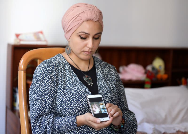 Fida Al Waer, a Syrian artist and teacher living in Beirut, poses as she holds a mobile phone in Beirut