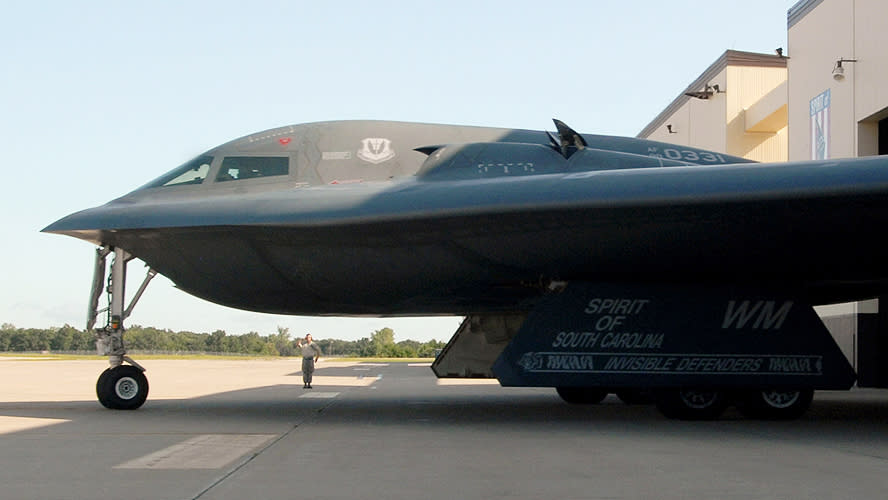 A member of the ground crew gives a “thumbs up” to B-2 pilots after marshaling them out of a hangar at Whiteman Air Force Base, Missouri. <em>U.S. Air Force photo/Senior Airman Kenny Holston</em> A B-2 taxiing out with its auxiliary air inlets popped open. (U.S. Air Force photo/Senior Airman Kenny Holston)