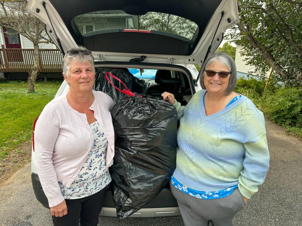 Gerry Cobbett, right, picked up her sister Mary Ann Clarke — and her garbage — on Wednesday, and the two took their bags directly to the landfill.  (Roger Cosman/CBC - image credit)