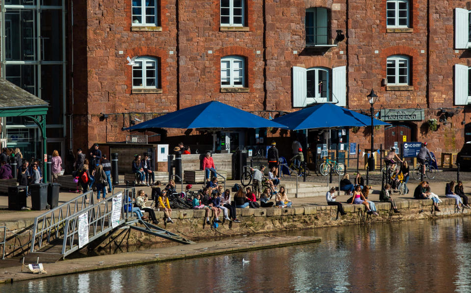 People enjoy the sunshine at the Exeter Quay in Devon. (SWNS)