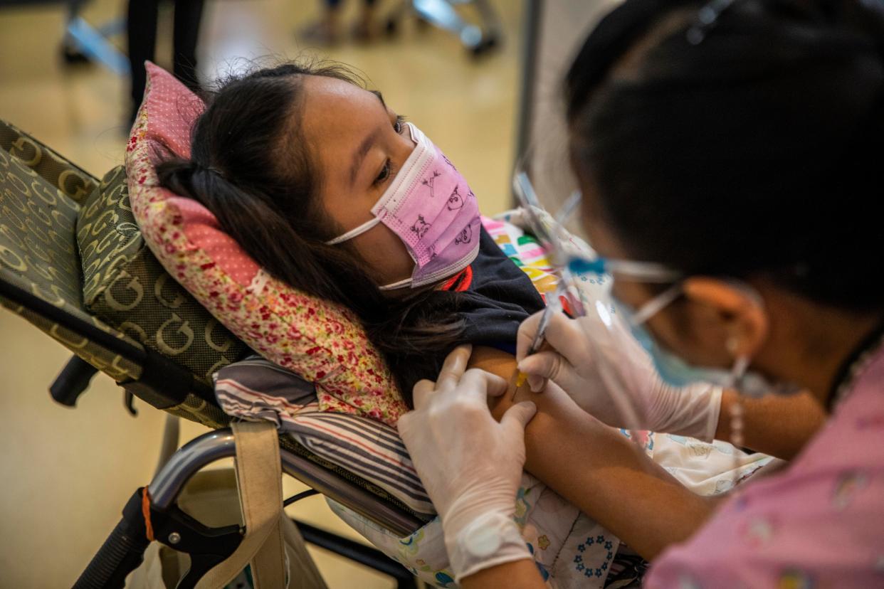 A teenage Thai girl who is wheelchair-bound receives her first dose of Pfizer's COVID-19 vaccine at Vachira Hospital on Sept. 21, 2021, in Bangkok, Thailand.