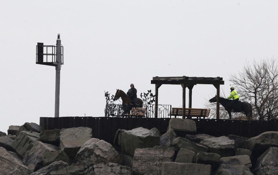 Members of the Cleveland Police Mounted Unit ride the Lake Erie shoreline, Tuesday, Jan. 3, 2017, in Cleveland. Cleveland officials say the search for a plane carrying six people that disappeared last week over Lake Erie has resumed. Tuesday marks the third straight day that conditions have allowed recovery teams to search the lake for a Columbus-bound Cessna 525 Citation that vanished from radar shortly after takeoff Thursday night from Burke Lakefront Airport. (AP Photo/Tony Dejak)