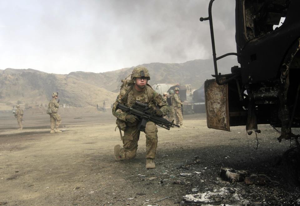 U.S. soldiers arrive at the site of burning NATO supply trucks after an attack by militants in the Torkham area near the Pakistani-Afghan in Nangarhar Province June 19, 2014. (REUTERS/ Parwiz)