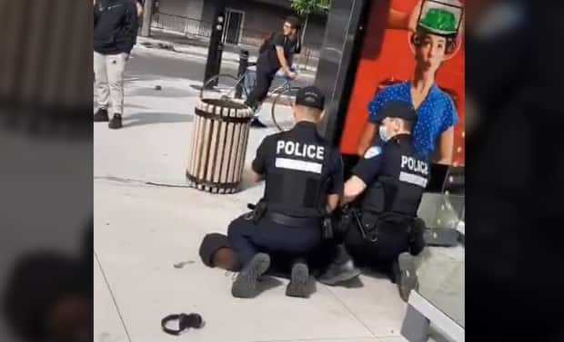 The video shows two white Montreal police officers kneeling on a Black teenager on June 10. CBC is blurring the face of the teen to protect his identity. (Screen shot from video obtained by Radio-Canada - image credit)