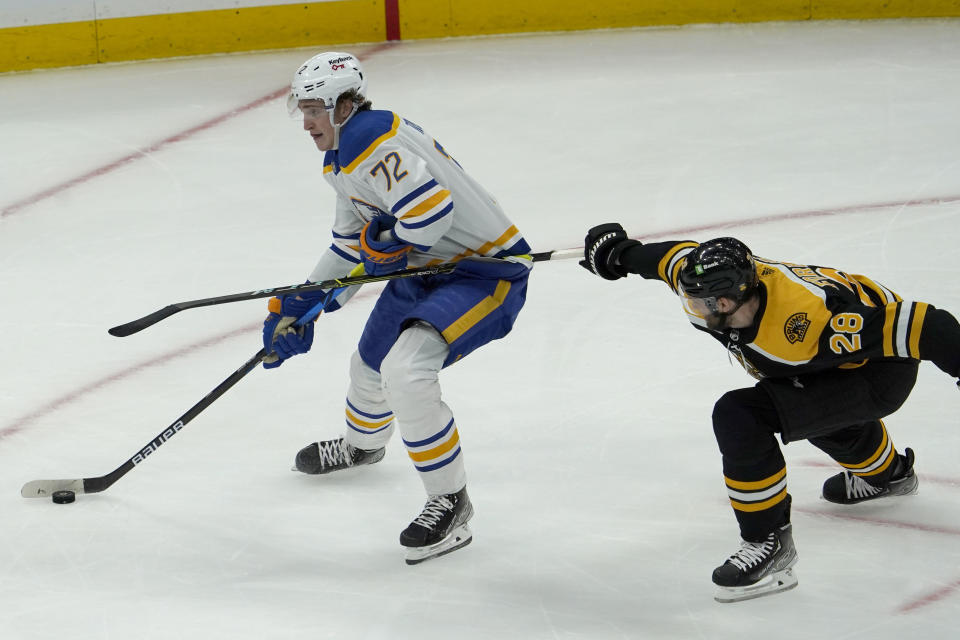 Buffalo Sabres right wing Tage Thompson (72) carries the puck ahead of Boston Bruins defenseman Derek Forbort (28) during the first period of an NHL hockey game, Saturday, Jan. 1, 2022, in Boston. (AP Photo/Mary Schwalm)