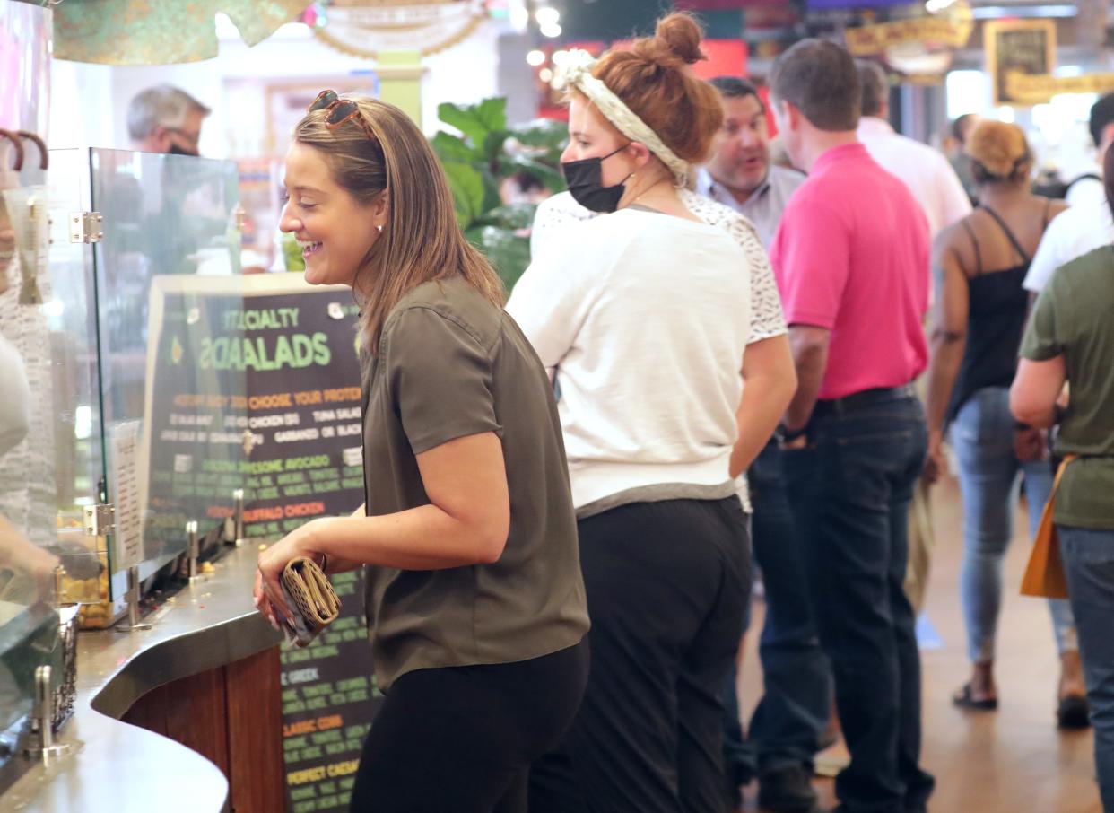 Lauren Zembrowski orders a salad at the Public Market on North Water Street in Milwaukee on Tuesday, June 1, 2021. The City of Milwaukee's previous mask ordinance ended that day, turning decisions about wearing face coverings over to individuals and businesses. The city reinstituted a mask mandate Jan. 18.