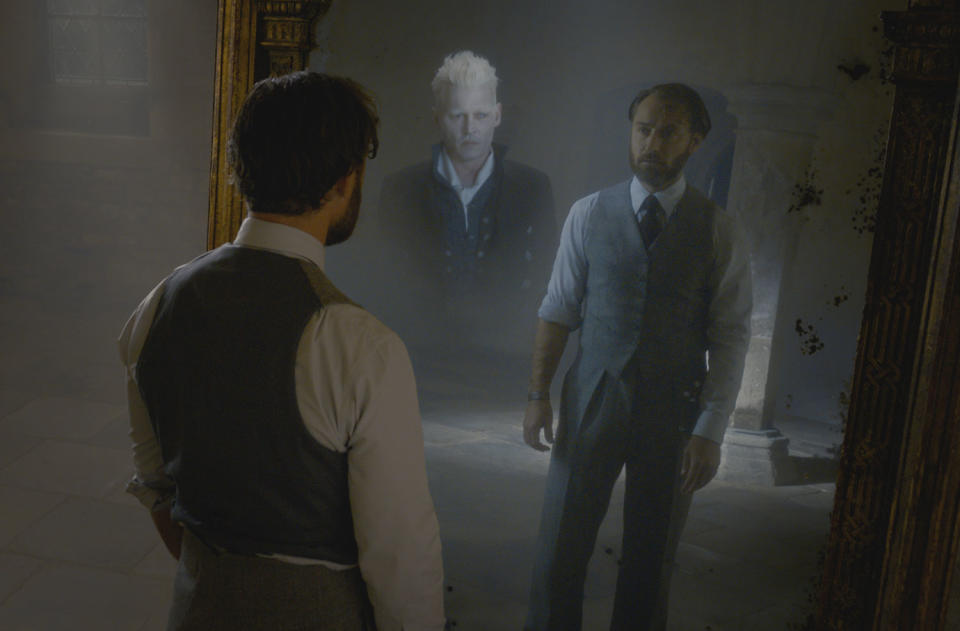 Jude Law sees his reflection and the image of Johnny Depp in a mirror in <i>Fantastic Beasts: The Crimes of Grindelwald.</i> (Photo: Warner Bros.)