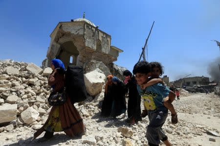 Displaced Iraqi civilians walk past near the ruined Grand al-Nuri Mosque after fleeing from the Old City in Mosul, Iraq, June 30, 2017. REUTERS/Alaa Al-Marjani