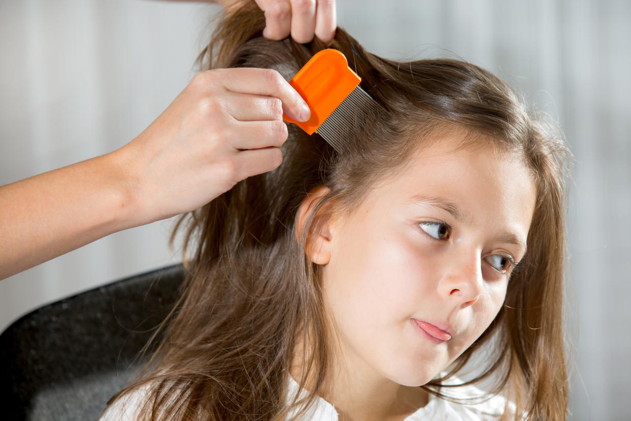 A mother using a comb to look for head lice