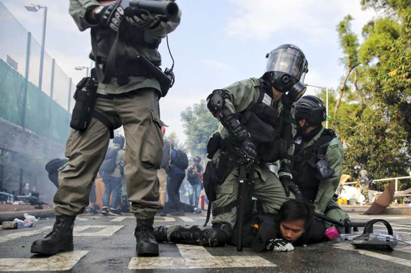 12日，在警民衝突最嚴重的香港中文大學校園，警方壓制一名學生。（AP）