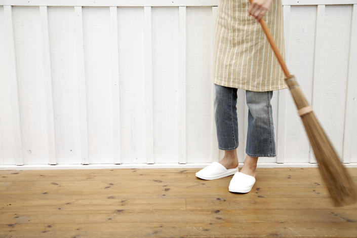 A woman is seen sweeping the floor. (PHOTO: Getty Images)