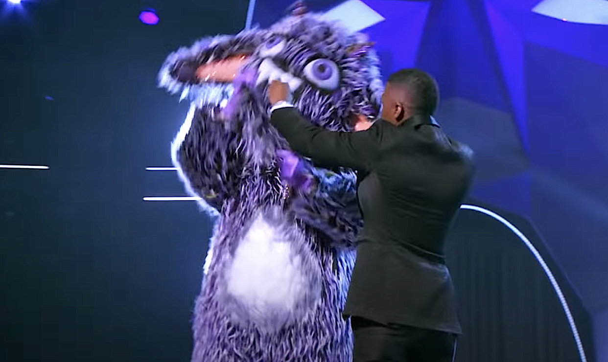 Host Nick Cannon tries to stop the Gremlin from ripping off his own costume on 'The Masked Singer' Season 4. (Photo: Fox)