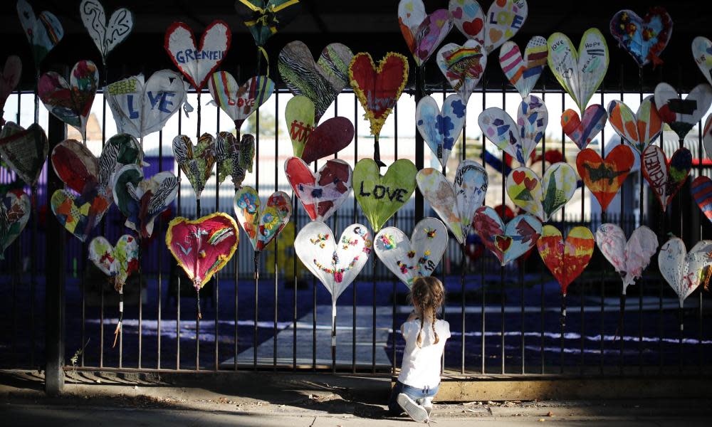 DOUNIAMAG-BRITAIN-FIRE-CARNIVAL-LIFESTYLEA young girl adds finishing touches to paper hearts adorning a fence in Kensington, near the burnt-out remains of Grenfell Tower in London on August 25, 2017 ahead of the Notting Hill Carnival. The art work is being made by volunteers from the community devestated by the Grenfell tower fire disaster as part of a project called Green for Grenfell in which paper hearts, banners, posters and bunting relating to the Grenfell tower tragedy are being made out of recycled materials to adorn the streets in time for the Notting Hill Carnival this coming weekend. / AFP PHOTO / Tolga AKMEN (Photo credit should read TOLGA AKMEN/AFP/Getty Images)