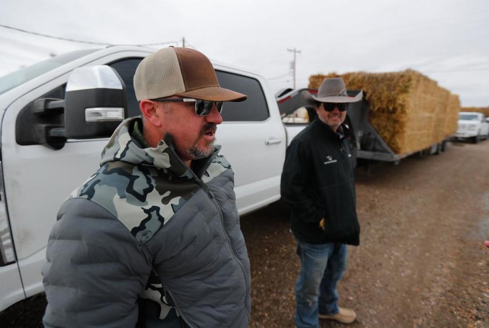 From left, Chad Merritt and Casey Smith, of Midland, stand outside of their trucks at the Texas R.V. Park in Fritch, Tx. The two were hauling hay to help ranchers feed their livestock whose grass was destroyed by the fire. Residents have been working to recover from the Tuesday grass fires that devastated parts of the panhandle.