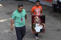 The brother of Myuran Sukumaran carries a self-portrait painting made by the Australian death row prisoner after making their final visit to the Nusakambangan prison island on April 28, 2015