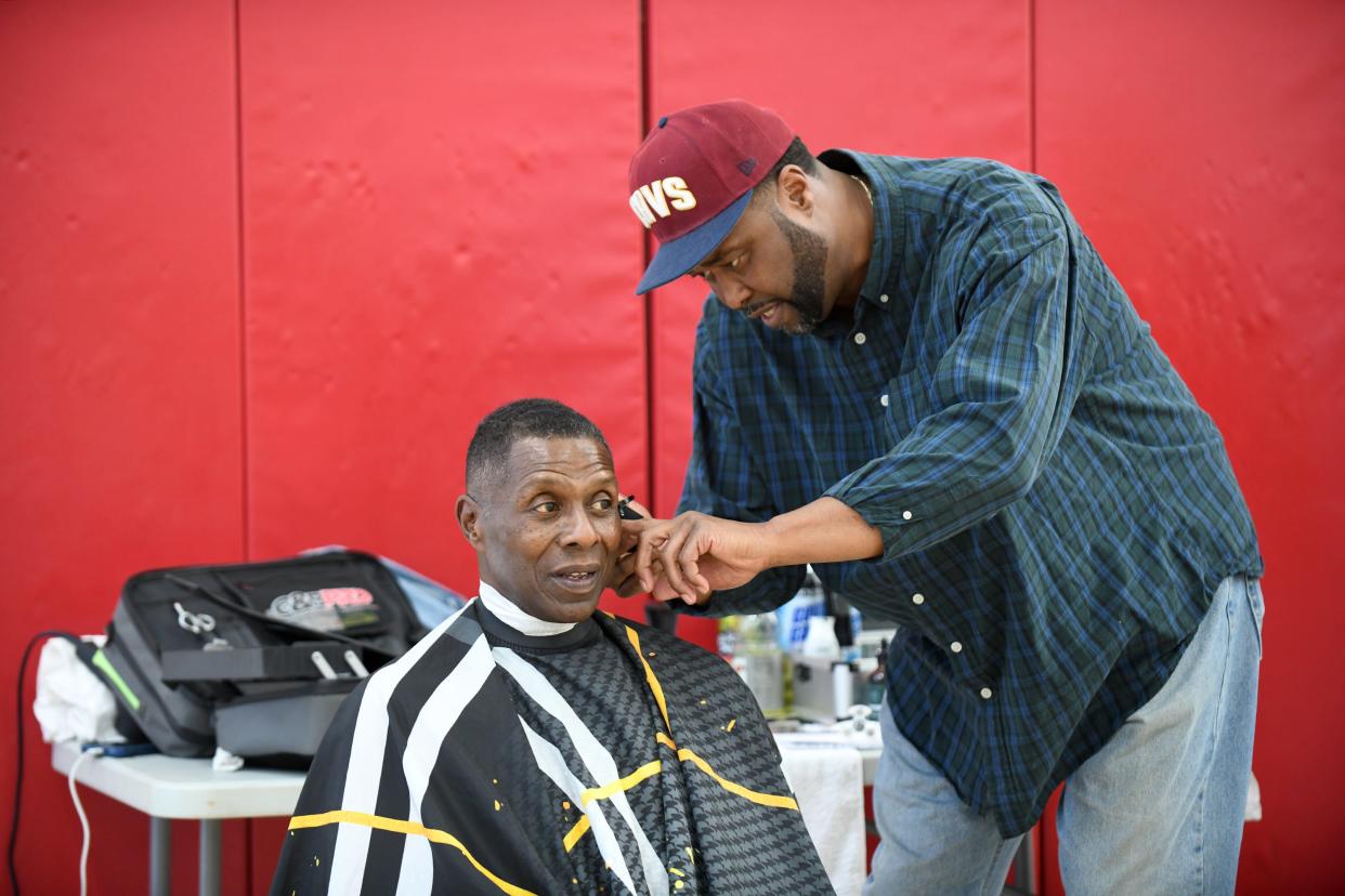 Anthony Robinson of Culler's Barber Shop 2.0 gives Army veteran Fred Haywood a haircut last week when more than 60 people attended a veterans' resources fair hosted by the Eric Snow YMCA in downtown Canton. The event was organized by Navy veteran Tam Church.