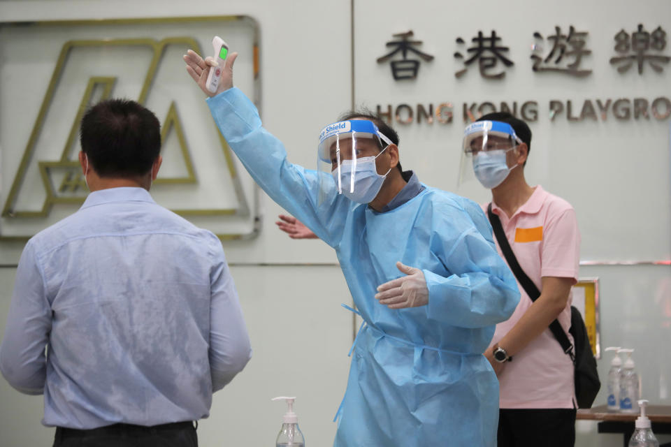 A man receives temperature check at a coronavirus testing center in Hong Kong, Tuesday, Sept. 1, 2020. Hong Kong began a voluntary mass-testing program for coronavirus Tuesday as part of a strategy to break the chain of transmission in the city's third outbreak of the disease. The virus-testing program has become a flash point of political debate in Hong Kong, with many distrustful over resources and staff being provided by the China's central government and fears that the residents’ DNA could be collected during the exercise (AP Photo/Kin Cheung)