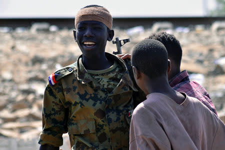 A Sudanese military officer and demonstrators celebrate after Defence Minister Awad Ibn Auf stepped down as head of the country's transitional ruling military council, as protesters demanded quicker political change, near the Defence Ministry in Khartoum, Sudan April 13, 2019. REUTERS/Stringer