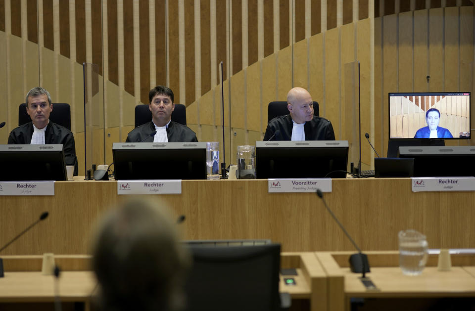 Presiding judge Hendrik Steenhuis, right, looks at a television monitor during the ongoing trial and criminal proceedings regarding the downing of Malaysia Airlines flight MH17, at the high security court at Schiphol airport, near Amsterdam, Netherlands, Monday Dec. 20, 2021. Prosecutors are scheduled to begin explaining evidence and their case to judges Monday in the murder trial of three Russians and a Ukrainian charged with involvement in downing Malaysia Airlines flight MH17 over eastern Ukraine in 2014, killing all 298 passengers and crew. (AP Photo/Peter Dejong)