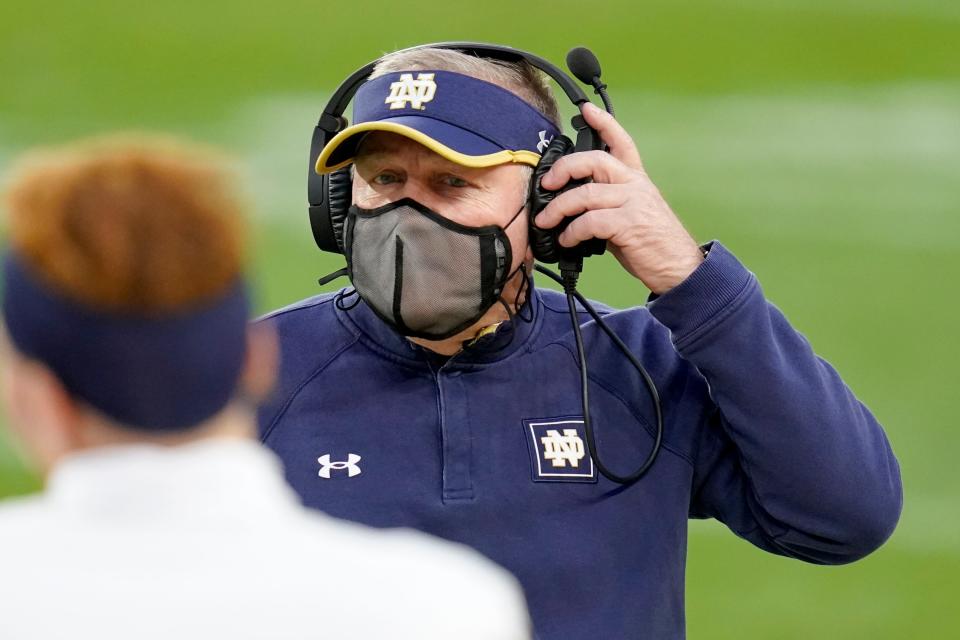 Notre Dame head coach Brian Kelly adjusts his headset as he walks to talk to Jonathan Doerer during the second half of an NCAA college football game against Pittsburgh, Saturday, Oct. 24, 2020, in Pittsburgh.