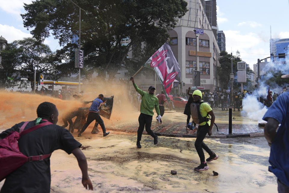 FILE - Protesters scatter as Kenya police spray a water canon at them during a protest over proposed tax hikes in a finance bill in downtown Nairobi, Kenya on June. 25, 2024. The ballooning debt in East Africa's economic hub of Kenya is expected to grow even more after deadly protests forced the rejection of a finance bill that President William Ruto said was needed to raise revenue. (AP Photo/Brian Inganga, File)