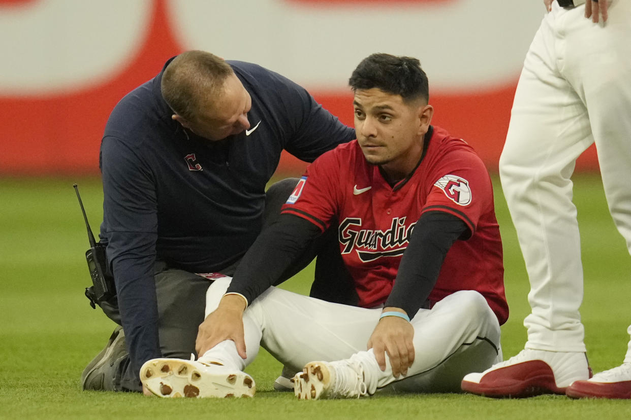 Cleveland Guardians second baseman Andres Gimenez, second from left, is checked out after colliding with second base umpire Chad Fairchild in the third inning of a baseball game against the Minnesota Twins, Monday, Sept. 16, 2024, in Cleveland. (AP Photo/Sue Ogrocki)