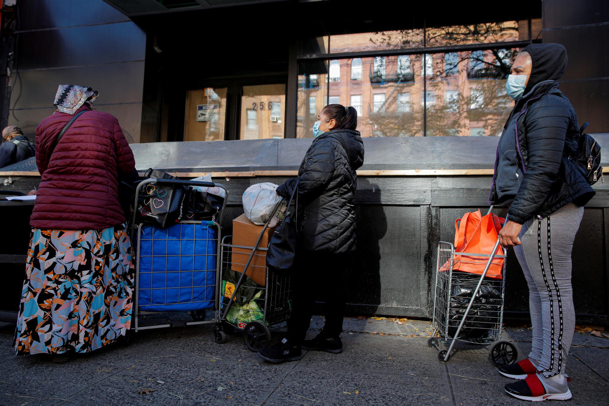 People line up to receive free holiday boxes of food from the Food Bank For New York City ahead of the Thanksgiving holiday, as the global outbreak of the coronavirus disease (COVID-19) continues, in the Harlem neighborhood of New York, U.S., November 16, 2020.  REUTERS/Brendan McDermid