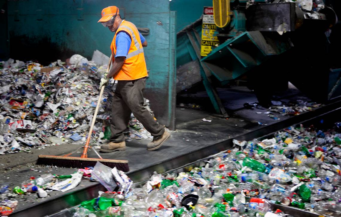 Ernesto Prudeste clears the floor under sorting machinery at Sonoco Recycling Center on Feb. 16, 2012.