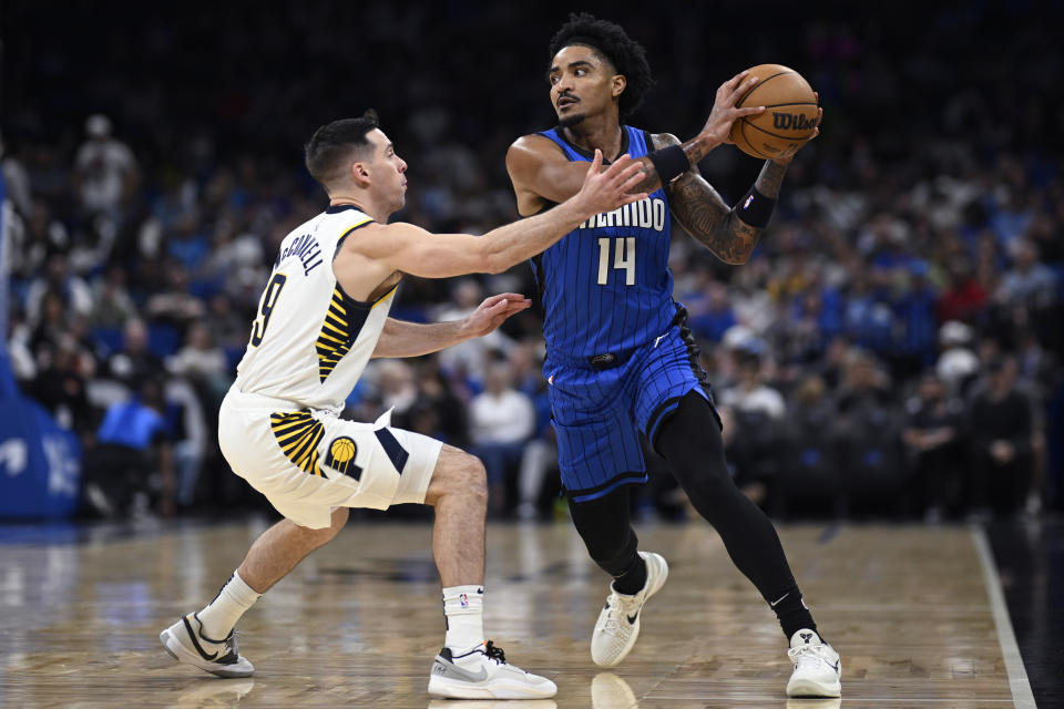 Orlando Magic guard Gary Harris (14) is defended by Indiana Pacers guard T.J. McConnell (9) during the first half of an NBA basketball game, Sunday, March 10, 2024, in Orlando, Fla. (AP Photo/Phelan M. Ebenhack)