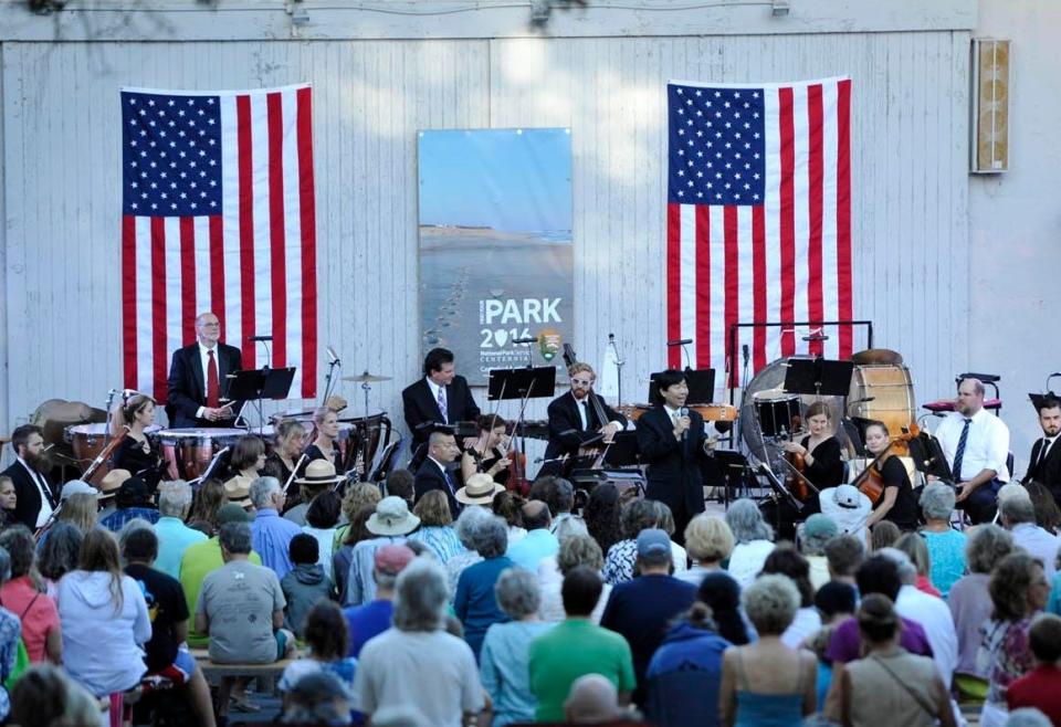 Conductor Jung-Ho Pak welcomes the crowd at the Cape Cod National Seashore's Salt Pond Visitors Center, in 2016. Members of the Cape Symphony played at an outdoor concert to celebrate the National Park Service centennial.