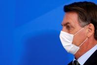 Brazil's President Jair Bolsonaro wearing a protective face mask arrives to a press statement to announce federal judiciary measures to curb the spread of the coronavirus disease (COVID-19) in Brasilia