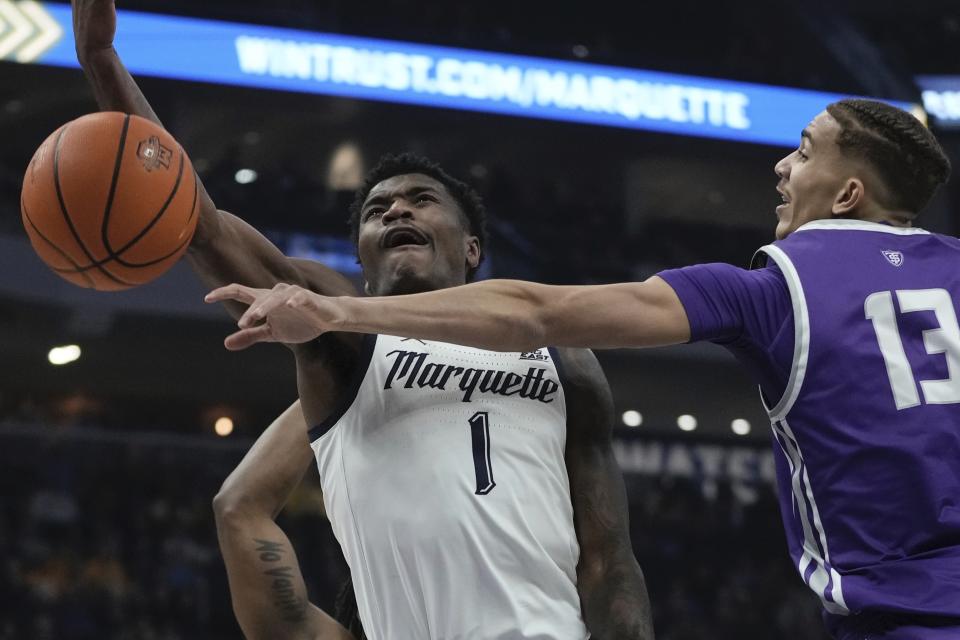 St. Thomas's Ahjany Lee knocks the ball from Marquette's Kam Jones during the first half of an NCAA college basketball game Thursday, Dec. 14, 2023, in Milwaukee. (AP Photo/Morry Gash)