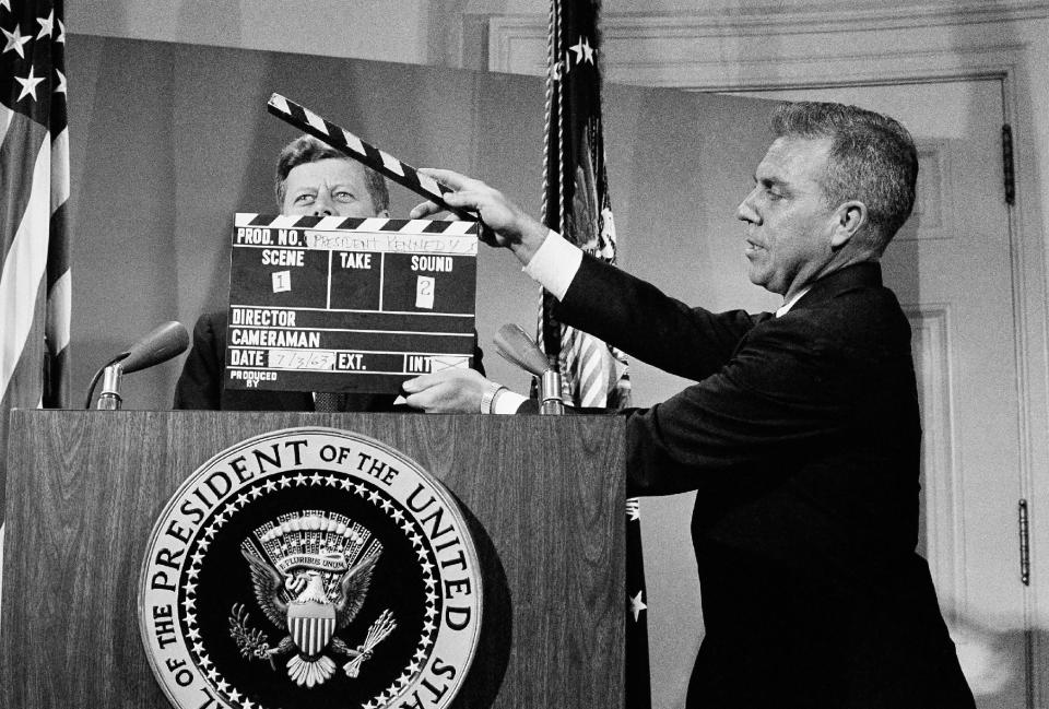 FILE - In this July 3, 1963 file photo, U.S. President John F. Kennedy stands at the lectern behind a production slate board during a television taping at the White House. In life and especially in death, Kennedy changed television forever. (AP Photo)