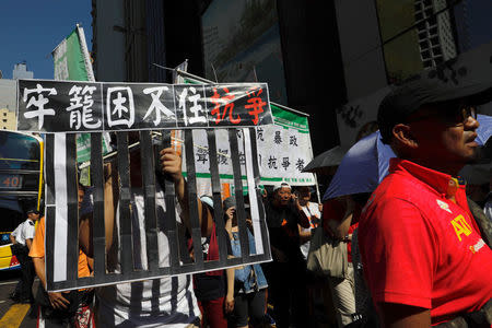 Demonstrators march in protest of the jailing of student leaders Joshua Wong, Nathan Law and Alex Chow who were imprisoned for their participation of the 2014 pro-democracy Umbrella Movement, also known as "Occupy Central" protests, in Hong Kong China August 20, 2017. The words on placard read: "Jail can't stop resistance." REUTERS/Tyrone Siu