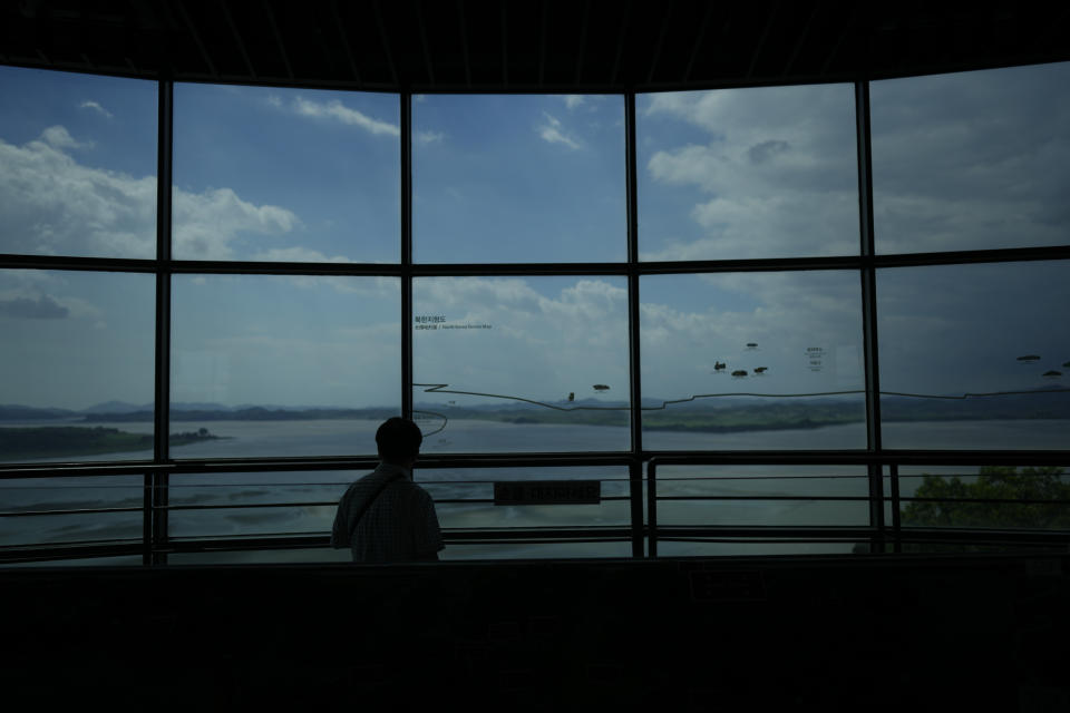 A visitor looks at the North Korean side from the unification observatory in Paju, South Korea, Tuesday, June 25, 2024. South Korea threatened Tuesday to restart anti-Pyongyang frontline propaganda broadcasts in the latest bout of Cold War-style campaigns between the rivals after North Korea resumed its trash-carrying balloon launches. (AP Photo/Lee Jin-man)