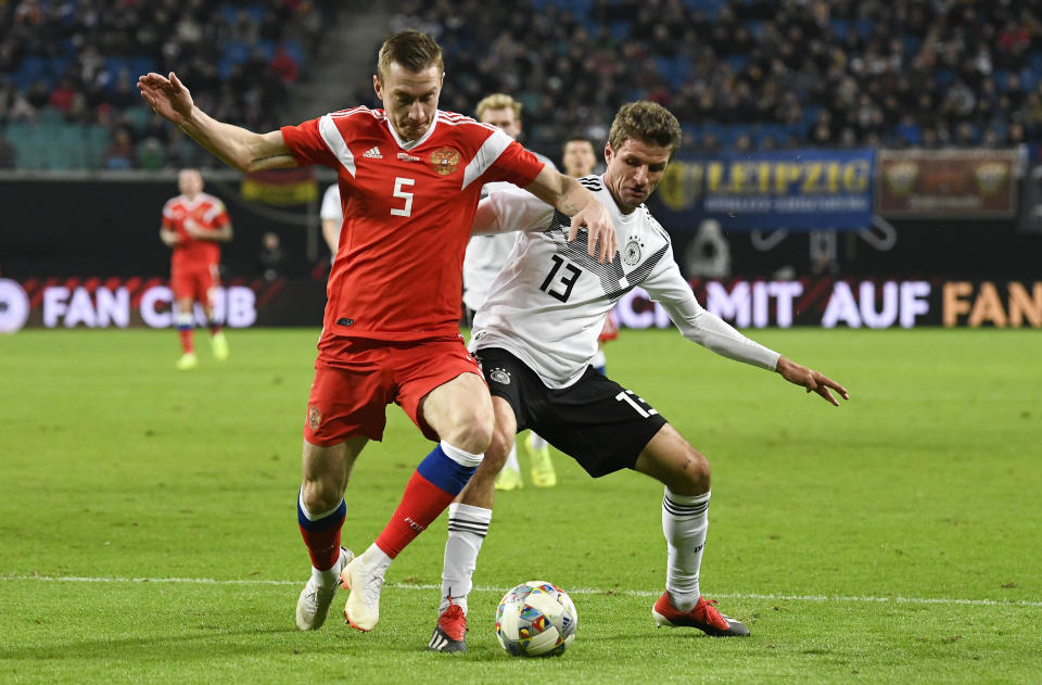 Russia's Andrey Semenov, left, and Germany's Thomas Mueller challenge for the ball during a friendly soccer match between Germany and Russia in Leipzig, Germany, Thursday, Nov. 15, 2018. (AP Photo/Jens Meyer)