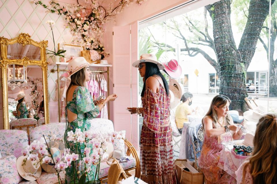 Corazon Playero founder Isabel Andrade, left, talks with a customer during the LoveShackFancy opening in Coconut Grove.