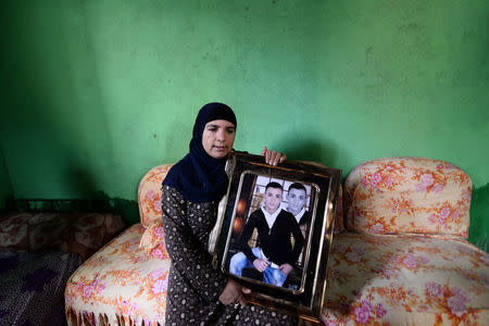 Halawethorn Abdel-Wahad poses with a photograph of her teenage nephew Fares Ezzat during an interview with Reuters at the family's home in the village of Meit Massoud in Aga, Egypt, November 16, 2016. REUTERS/Stringer